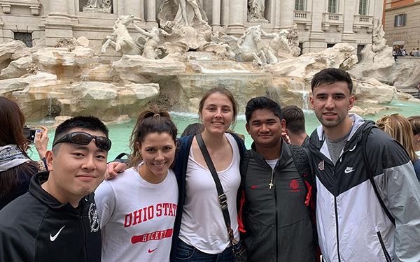 Students posing in front of a famous spot in Italy
