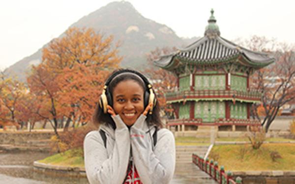 A female student posing in front of a building in Asia