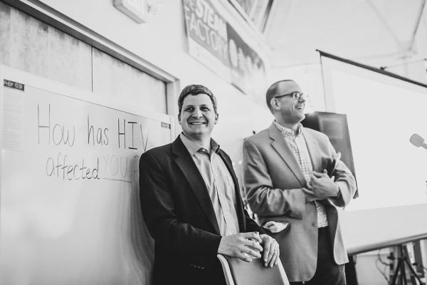 Associate professors Jesse Kwiek (left) of microbiology and Thomas McDow of history at the STEAM Factory for an event that concludes their co-taught course on HIV. Photo courtesy Paul Woo, Wandering Woo Photography Associate professors Jesse Kwiek (left) of microbiology and Thomas McDow of history at the STEAM Factory for an event that concludes their co-taught course on HIV. Photo courtesy Paul Woo, Wandering Woo Photography